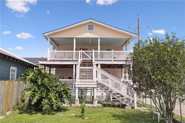 rear view of house with a wooden deck and a yard