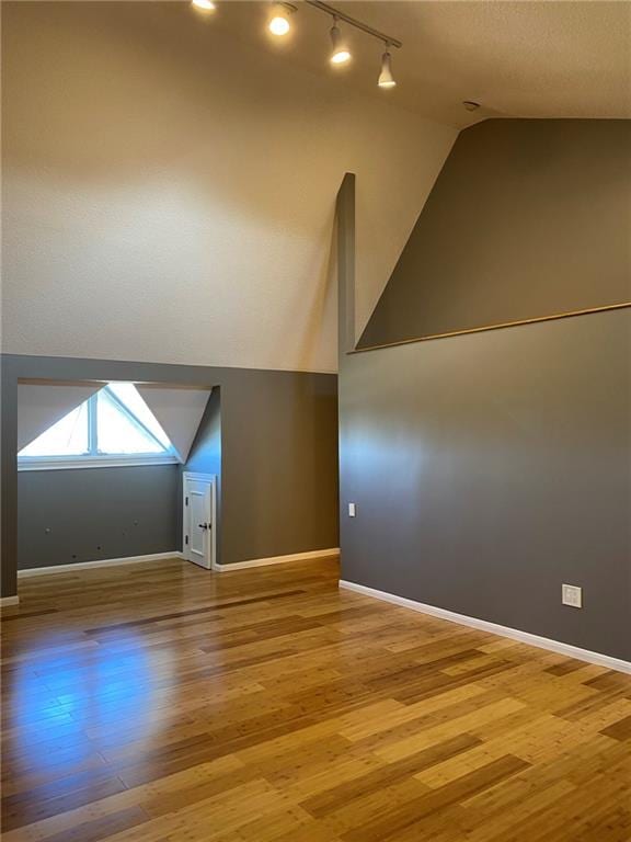 additional living space featuring vaulted ceiling and hardwood / wood-style floors