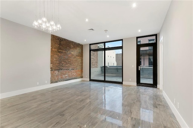 spare room featuring a notable chandelier and expansive windows