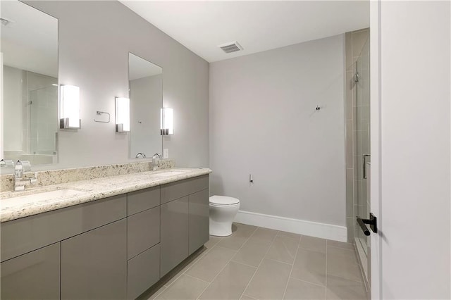 bathroom featuring tile patterned flooring, vanity, a shower with door, and toilet