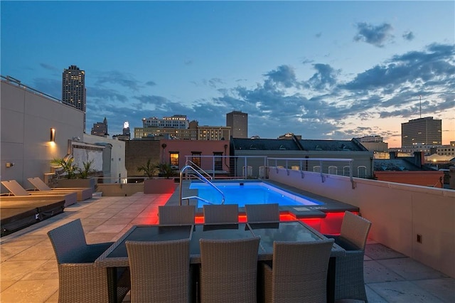 pool at dusk with a patio