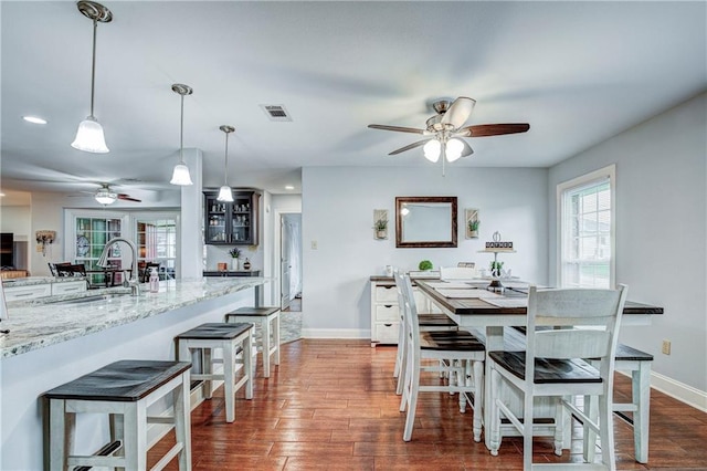 dining room featuring dark hardwood / wood-style floors, ceiling fan, and sink