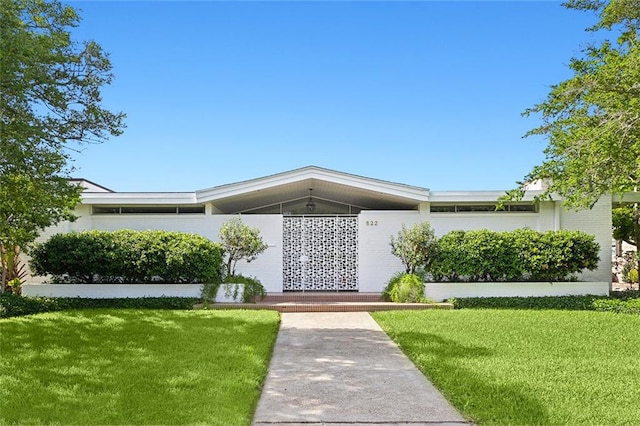 ranch-style home featuring a front lawn