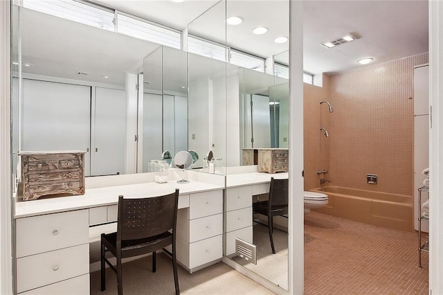 bathroom with vanity, tile patterned flooring, and tiled shower / bath