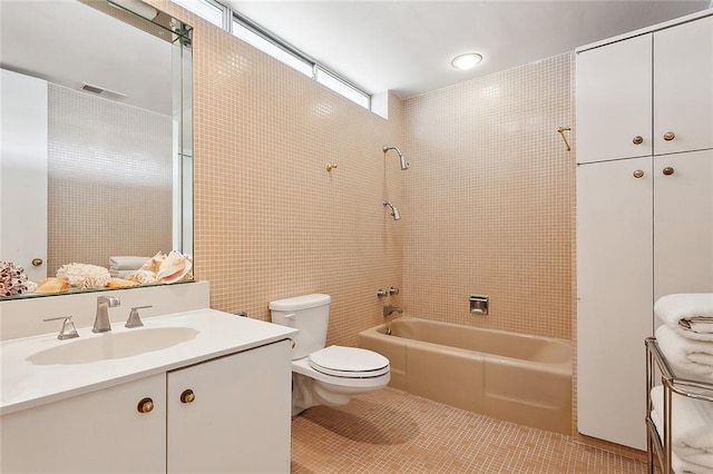 full bathroom featuring vanity, toilet, tiled shower / bath combo, and tile patterned flooring