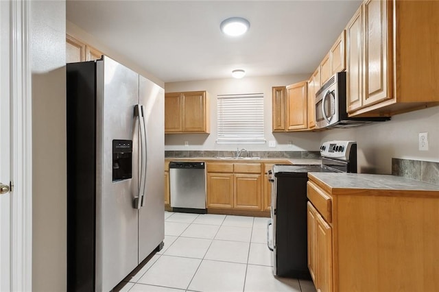 kitchen featuring light tile patterned floors, sink, and appliances with stainless steel finishes