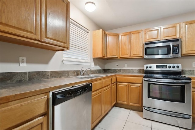 kitchen with light tile patterned floors, stainless steel appliances, and sink