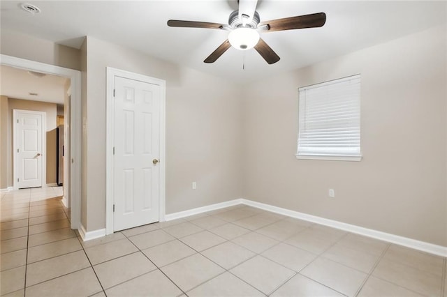 tiled spare room with ceiling fan