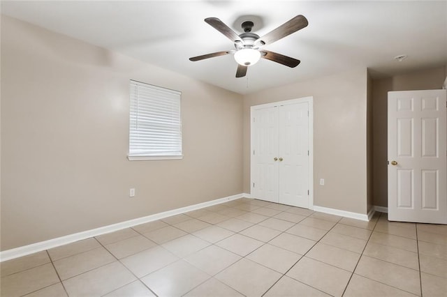 tiled spare room with ceiling fan