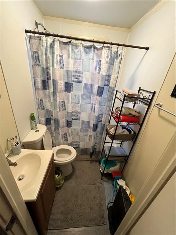 bathroom with tile flooring, toilet, and vanity