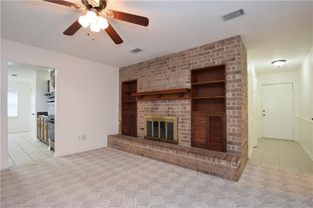 unfurnished living room with brick wall, a brick fireplace, ceiling fan, and light colored carpet