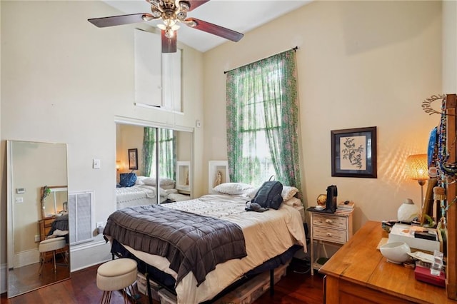 bedroom featuring multiple windows, dark wood-type flooring, and ceiling fan