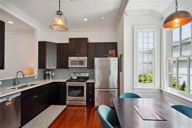 kitchen featuring sink, backsplash, pendant lighting, and appliances with stainless steel finishes