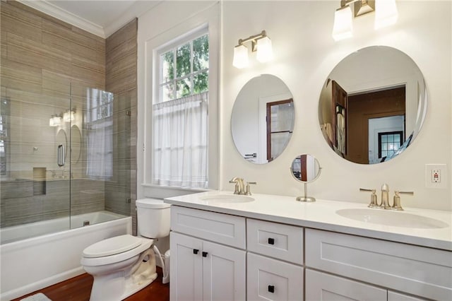 full bathroom featuring hardwood / wood-style floors, enclosed tub / shower combo, vanity, toilet, and crown molding