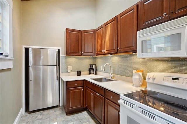 kitchen with sink, backsplash, and white appliances