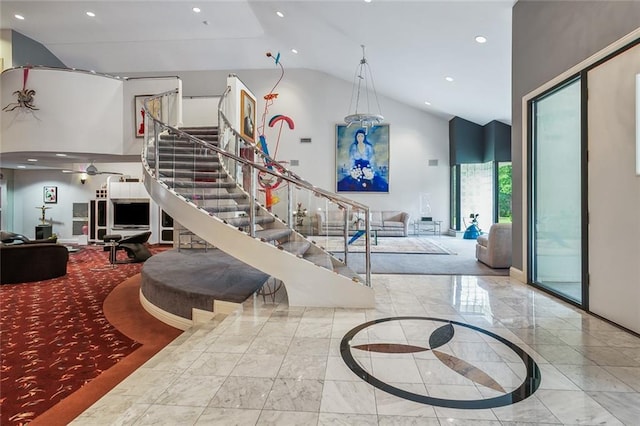 stairway featuring recessed lighting, high vaulted ceiling, marble finish floor, and baseboards