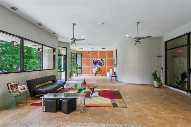 living area with ceiling fan and tile patterned flooring