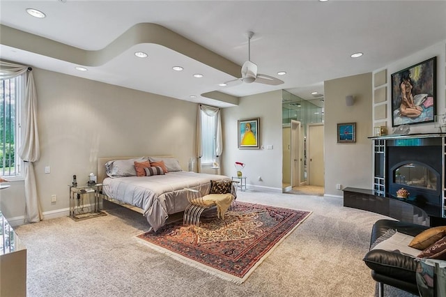 bedroom with a glass covered fireplace, recessed lighting, baseboards, and carpet