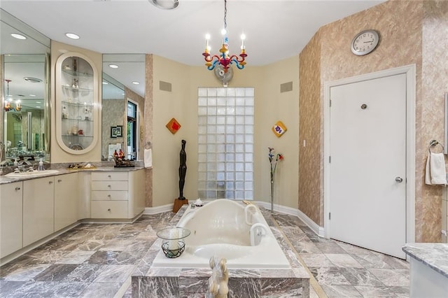 full bathroom with vanity, a garden tub, baseboards, and a chandelier