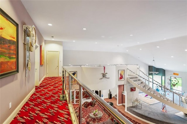 corridor featuring baseboards, carpet floors, lofted ceiling, recessed lighting, and stairs