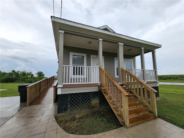 view of front of property featuring covered porch and a front lawn