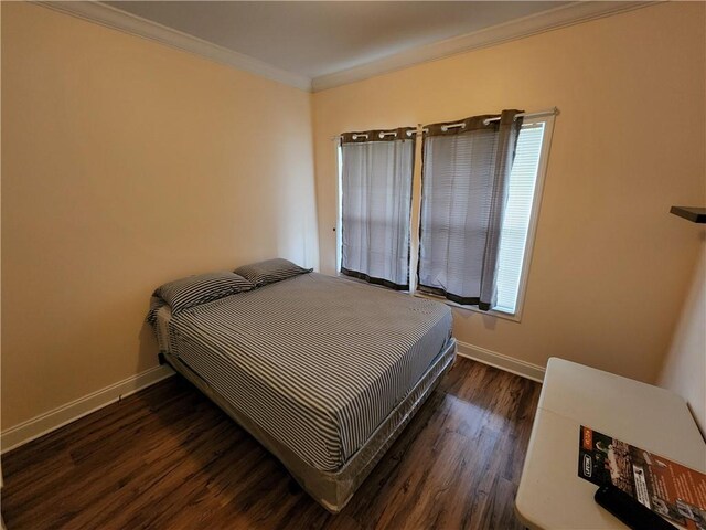 bedroom featuring crown molding and dark hardwood / wood-style floors