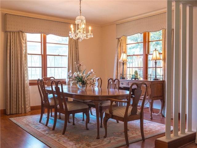 dining area featuring ornamental molding, wood-type flooring, and a chandelier