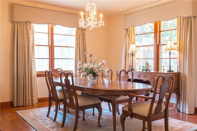 dining room featuring hardwood / wood-style flooring, crown molding, a chandelier, and a wealth of natural light