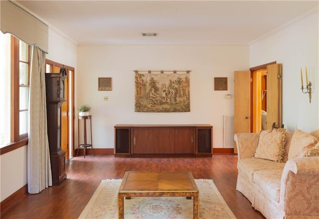 living room with dark hardwood / wood-style flooring and crown molding