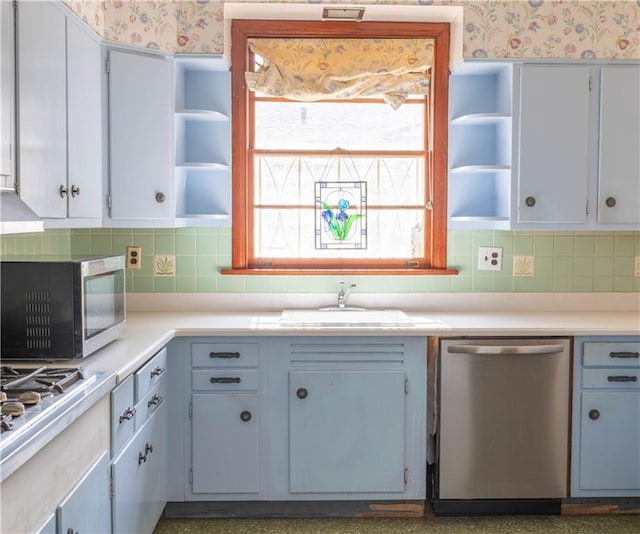 kitchen featuring stainless steel appliances, sink, and backsplash