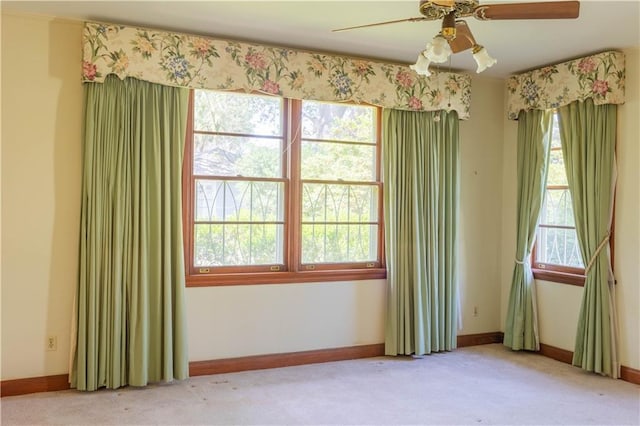 carpeted spare room with ceiling fan