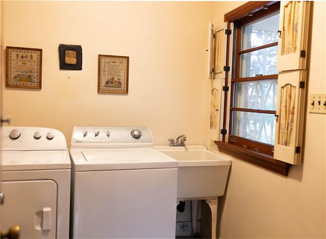 clothes washing area with independent washer and dryer and sink