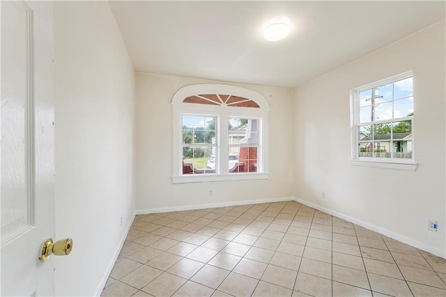 empty room featuring light tile patterned floors and plenty of natural light