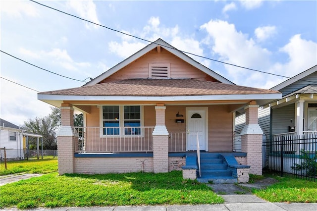 bungalow-style house with a front lawn and covered porch