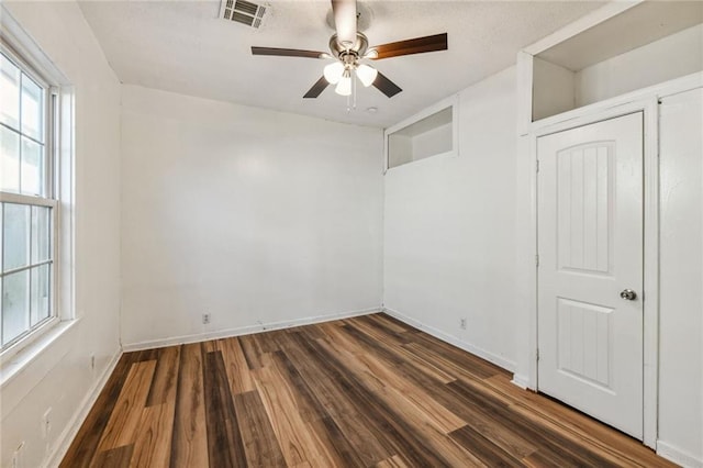 unfurnished room featuring ceiling fan and dark hardwood / wood-style flooring