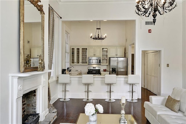 living room with dark hardwood / wood-style floors, an inviting chandelier, ornamental molding, and sink