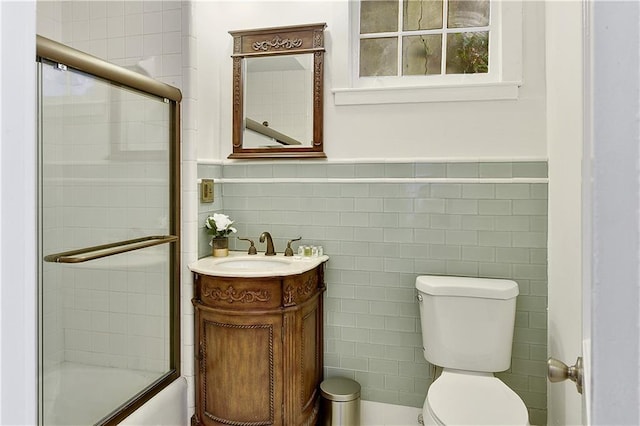 full bathroom with vanity, toilet, and enclosed tub / shower combo