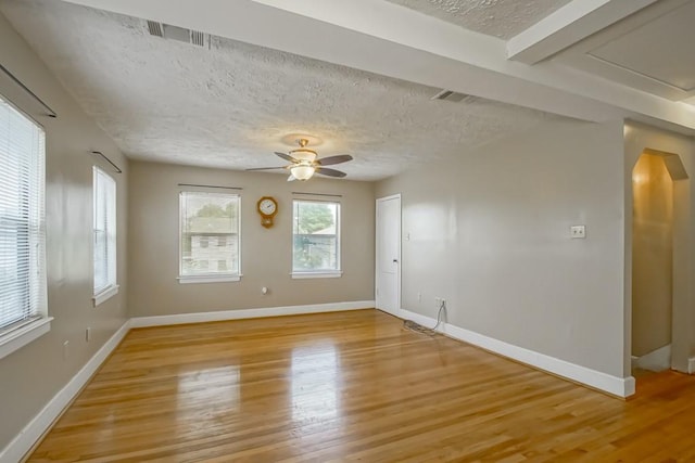 spare room featuring a textured ceiling, light hardwood / wood-style flooring, and ceiling fan