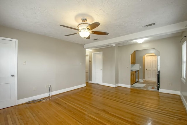 spare room featuring ceiling fan, light hardwood / wood-style flooring, and a textured ceiling