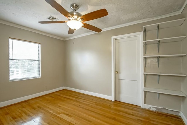 unfurnished bedroom with hardwood / wood-style floors, a textured ceiling, ceiling fan, and ornamental molding