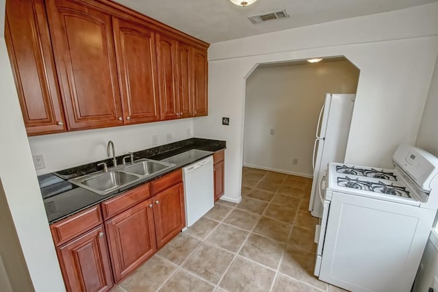 kitchen featuring light tile patterned floors, white appliances, and sink