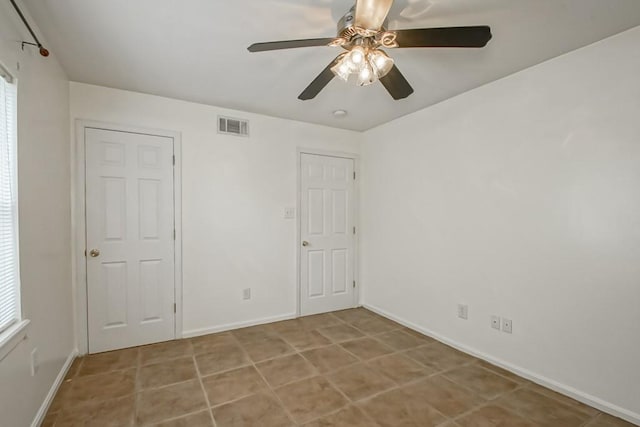 tiled empty room featuring ceiling fan