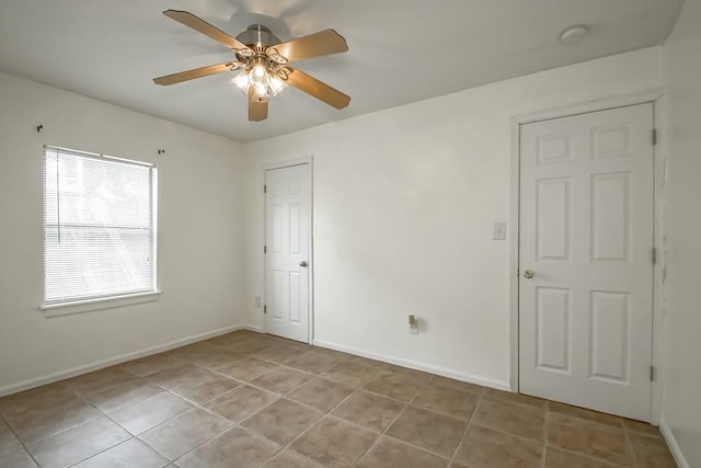 empty room featuring ceiling fan and light tile patterned floors