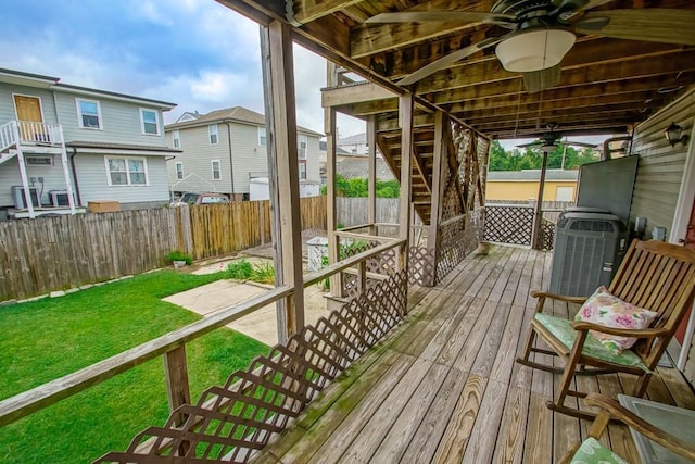 wooden deck featuring a lawn and ceiling fan