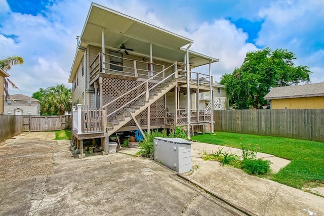 rear view of house featuring a yard and ceiling fan