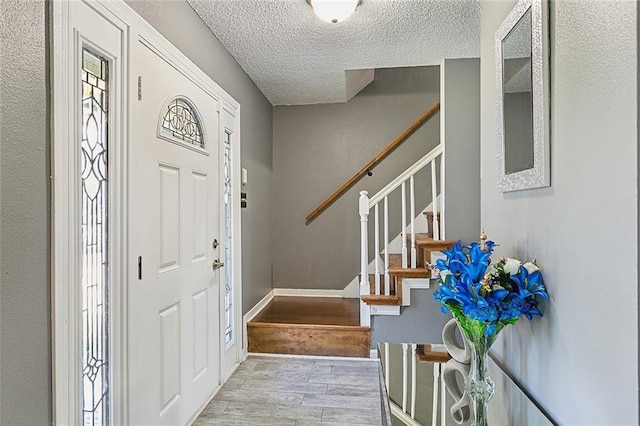 foyer featuring a textured ceiling and light hardwood / wood-style flooring