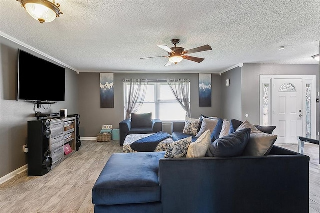 living room with crown molding, a textured ceiling, ceiling fan, and light hardwood / wood-style flooring