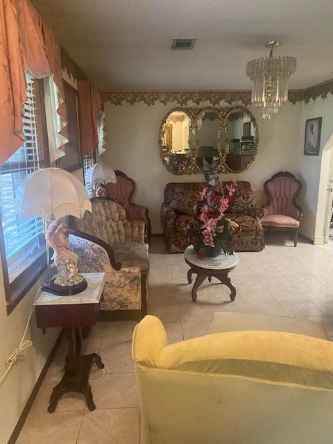 living room with a chandelier, light tile patterned floors, and a wealth of natural light