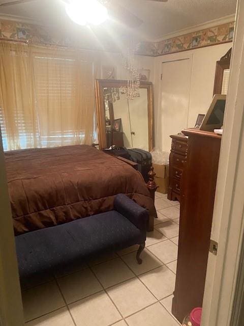 tiled bedroom featuring ornamental molding and ceiling fan