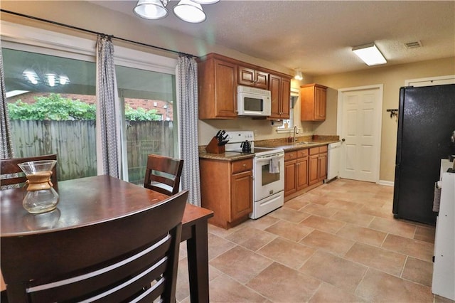 kitchen featuring a textured ceiling, sink, and white appliances